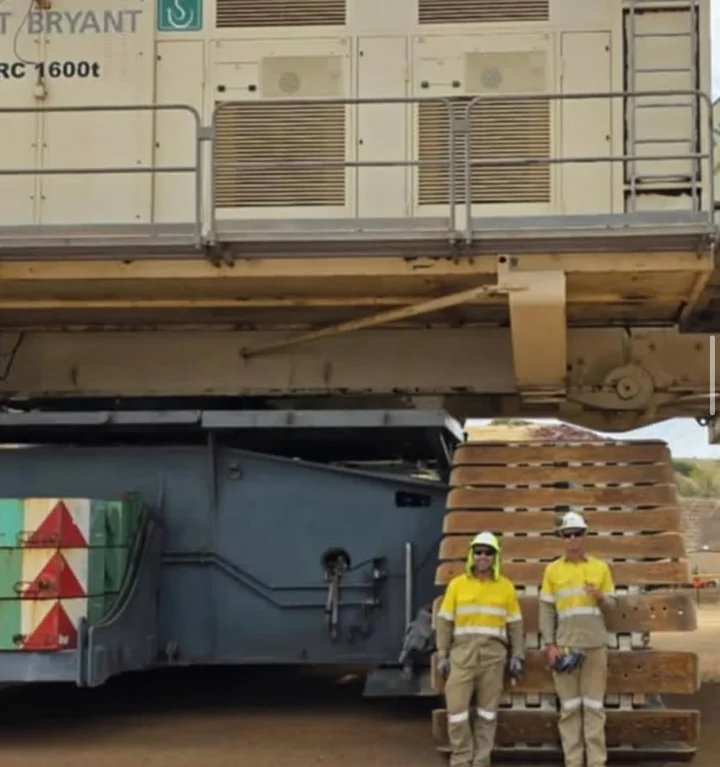 Standing with a workmate beside the dragline shoes at a mine site